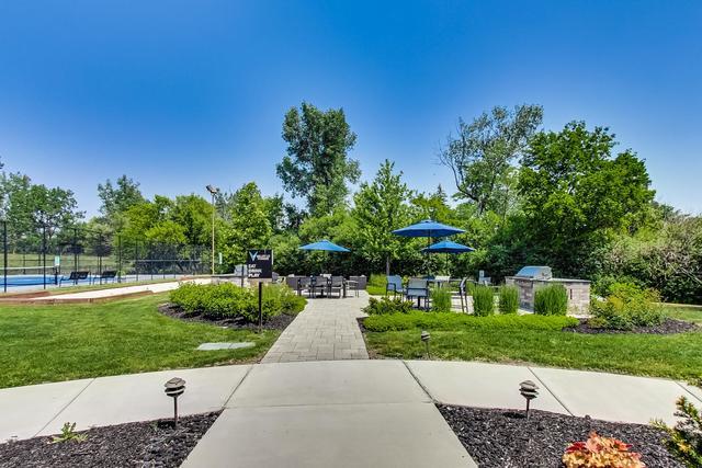 2000 Chestnut Avenue, Unit 407 Glenview, IL 60025 - Photo 21 of 25 a view of a garden with a bench in front of main