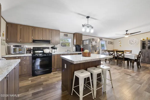 a kitchen with a dining table chairs stainless steel appliances and cabinets