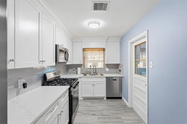 a kitchen with a sink stove top oven and cabinets
