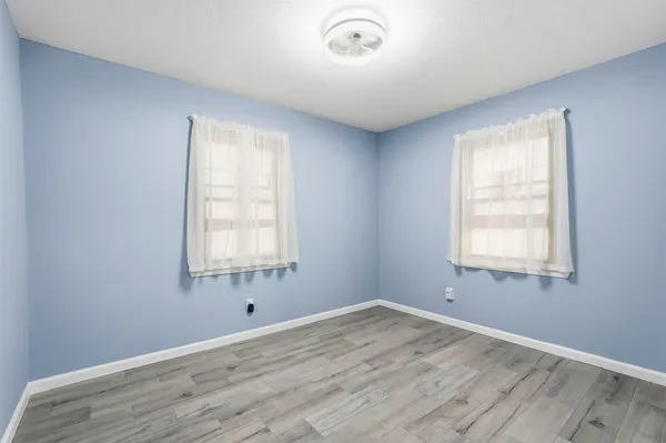 a view of a room with wooden floor and windows