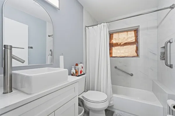 a white bath tub sitting next to a white toilet and a sink