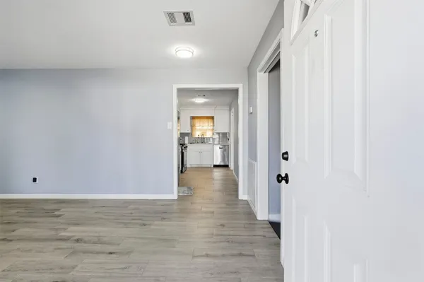 a view of a hallway with wooden floor and closet area