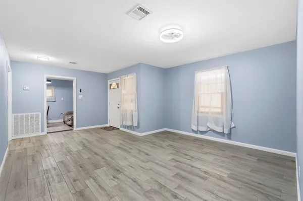 wooden floor in an empty room with a window