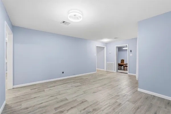 a view of an empty room with wooden floor