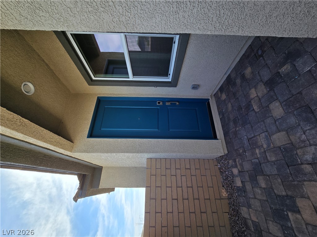 852 Weston Ridge Street Henderson, NV 89011 - Photo 4 of 28 A welcoming entry features a bold blue door, complementing the textured stucco and paver walkway.