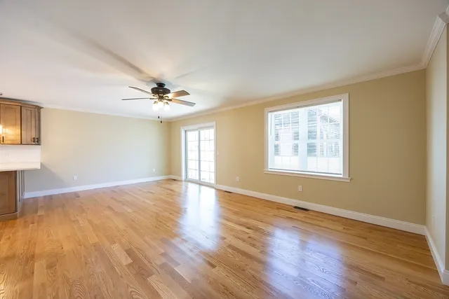a view of an empty room with window and a ceiling fan