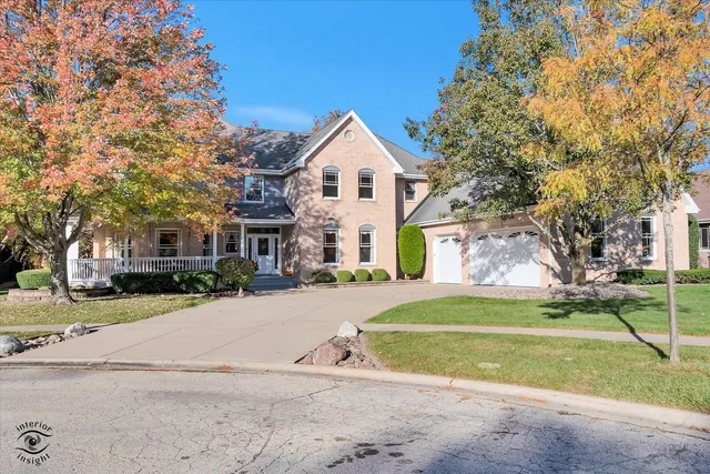 a view of a house with a yard and large trees