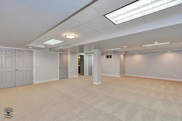 a view of an empty room with window and a kitchen