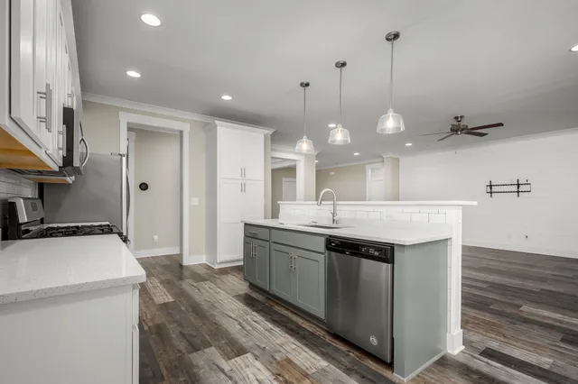 a kitchen with kitchen island a sink stainless steel appliances and cabinets