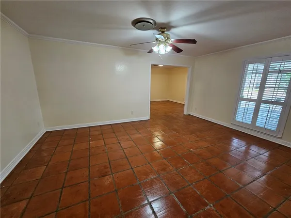 a view of an empty room with a chandelier fan