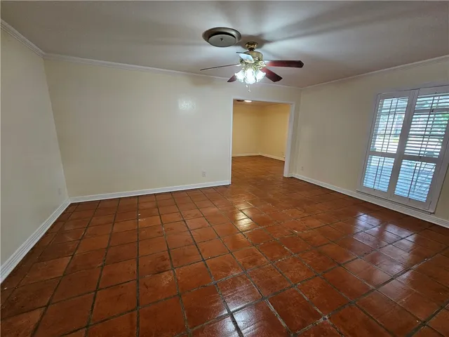 a view of an empty room with a chandelier fan