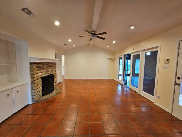 a view of an empty room with a fireplace and a window
