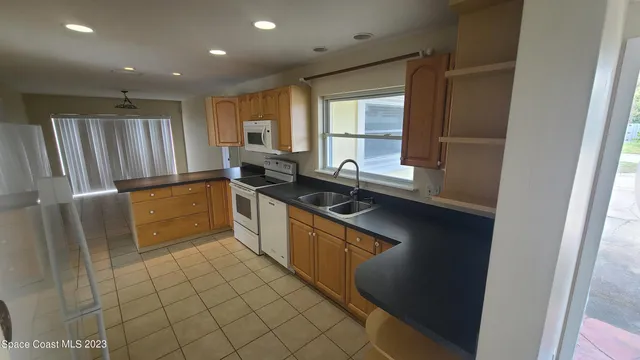 a kitchen with granite countertop a sink stove and refrigerator