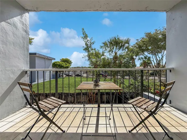 a view of a balcony with wooden floor & fence