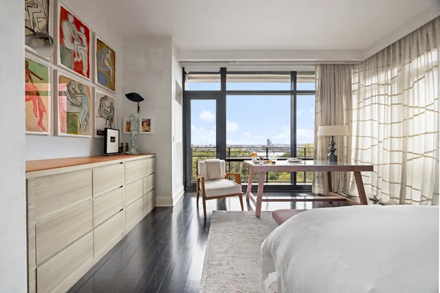 a spacious bedroom with a bed and glass windows