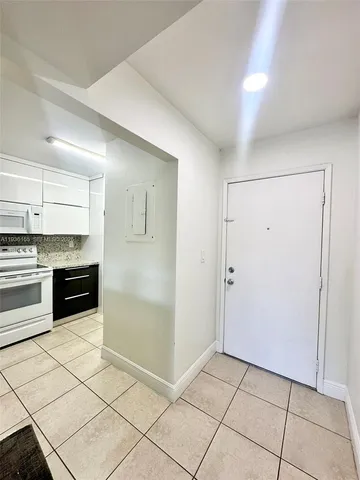a kitchen with granite countertop a refrigerator and a stove top oven