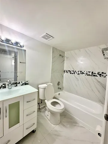 a bathroom with a sink toilet vanity and tub