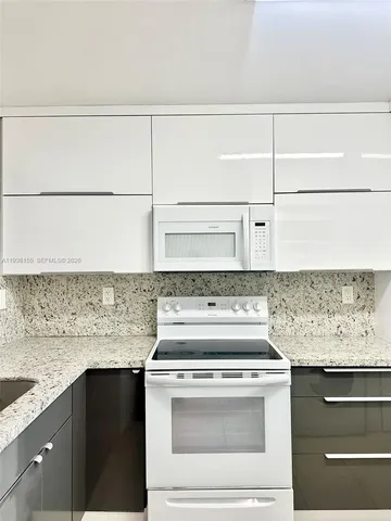 a kitchen with granite countertop cabinets stove and microwave