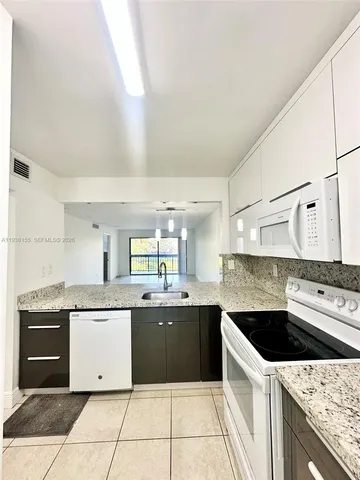 a kitchen with a stove sink and cabinets