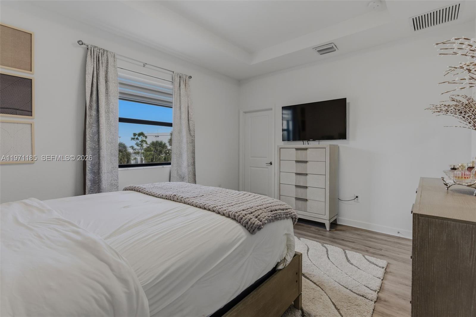 10009 Southwest 228th Terrace Miami, FL 33190 - Photo 19 of 48 a bedroom with a bed and a flat screen tv