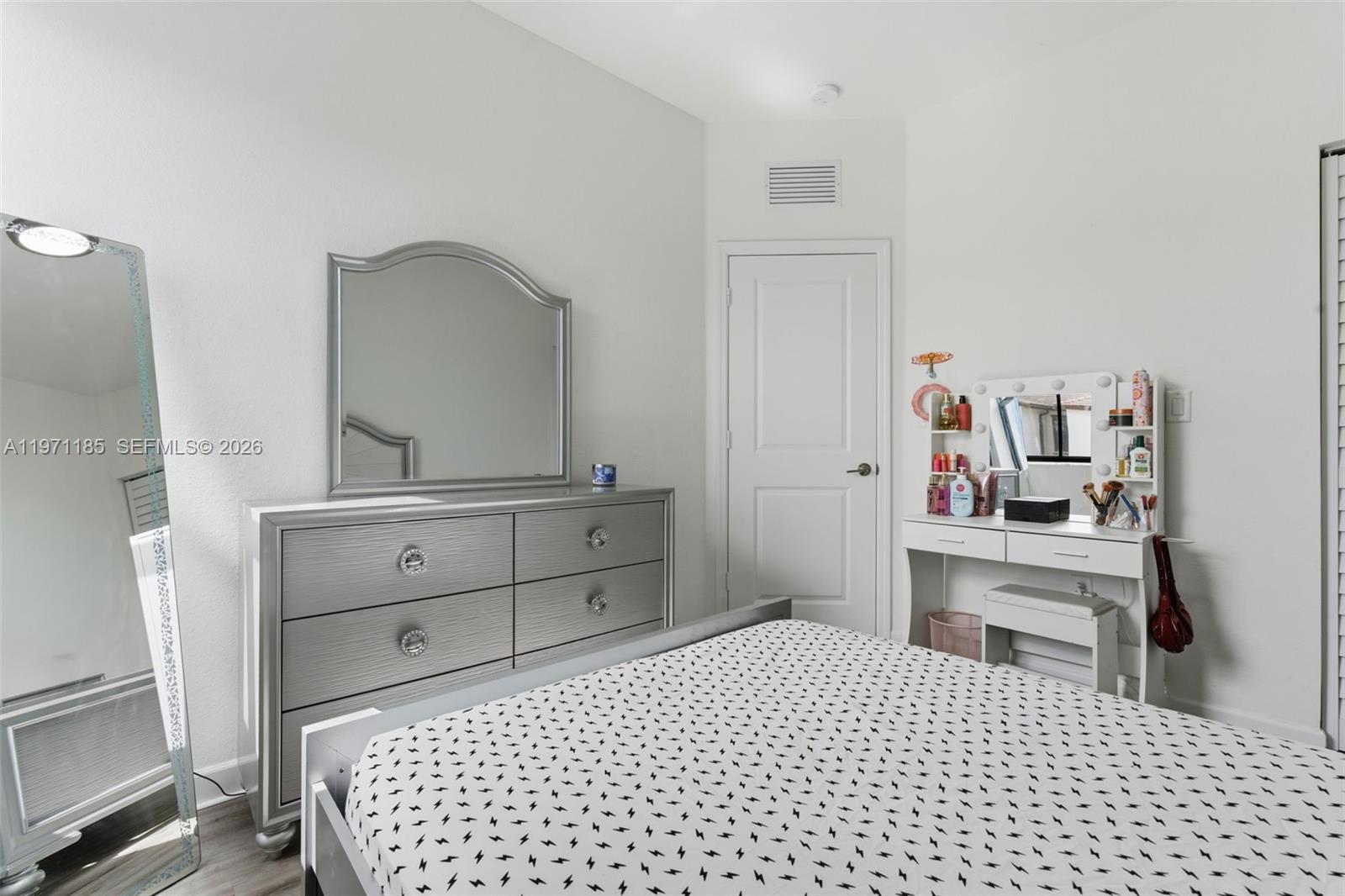 10009 Southwest 228th Terrace Miami, FL 33190 - Photo 24 of 48 a room with a bed and a mirror on dresser