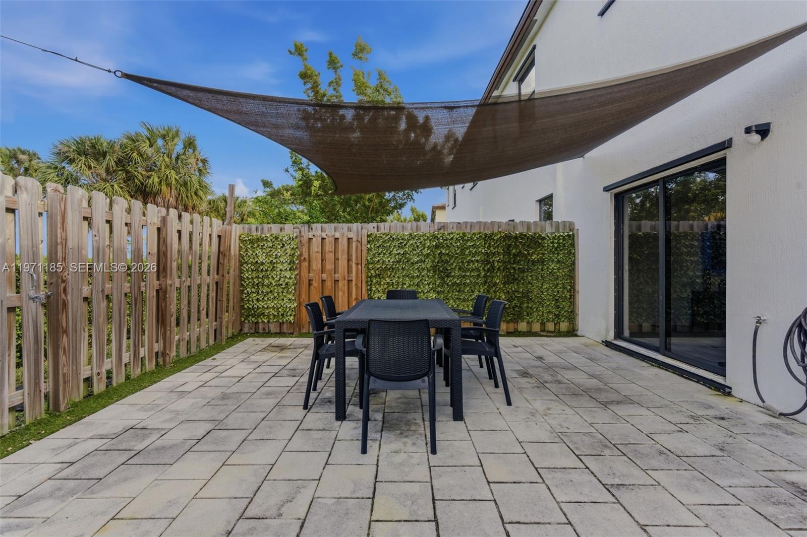 10009 Southwest 228th Terrace Miami, FL 33190 - Photo 31 of 48 a view of a patio with a table chairs and backyard
