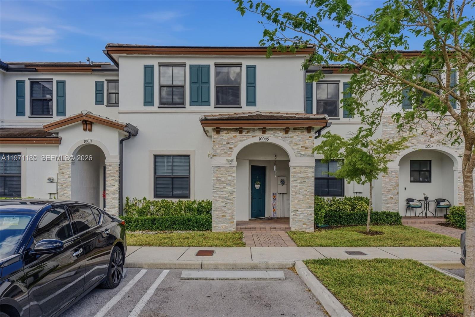 10009 Southwest 228th Terrace Miami, FL 33190 - Photo 34 of 48 a front view of a house with garden