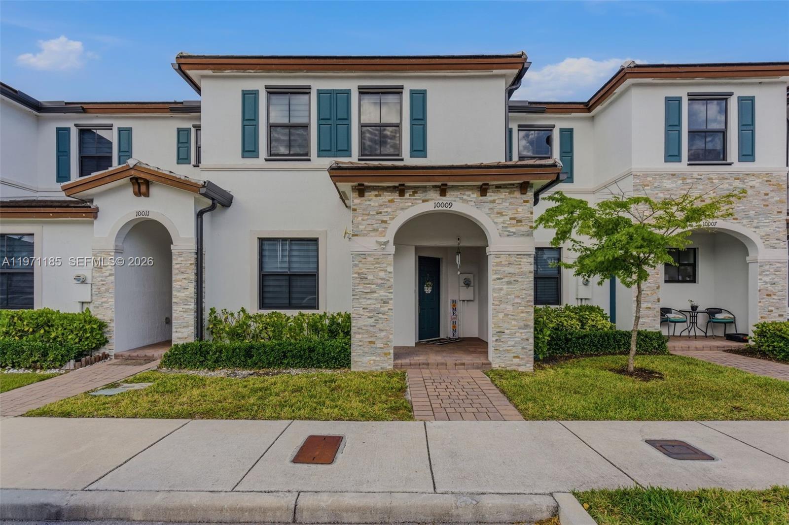 10009 Southwest 228th Terrace Miami, FL 33190 - Photo 35 of 48 a front view of a house with garden