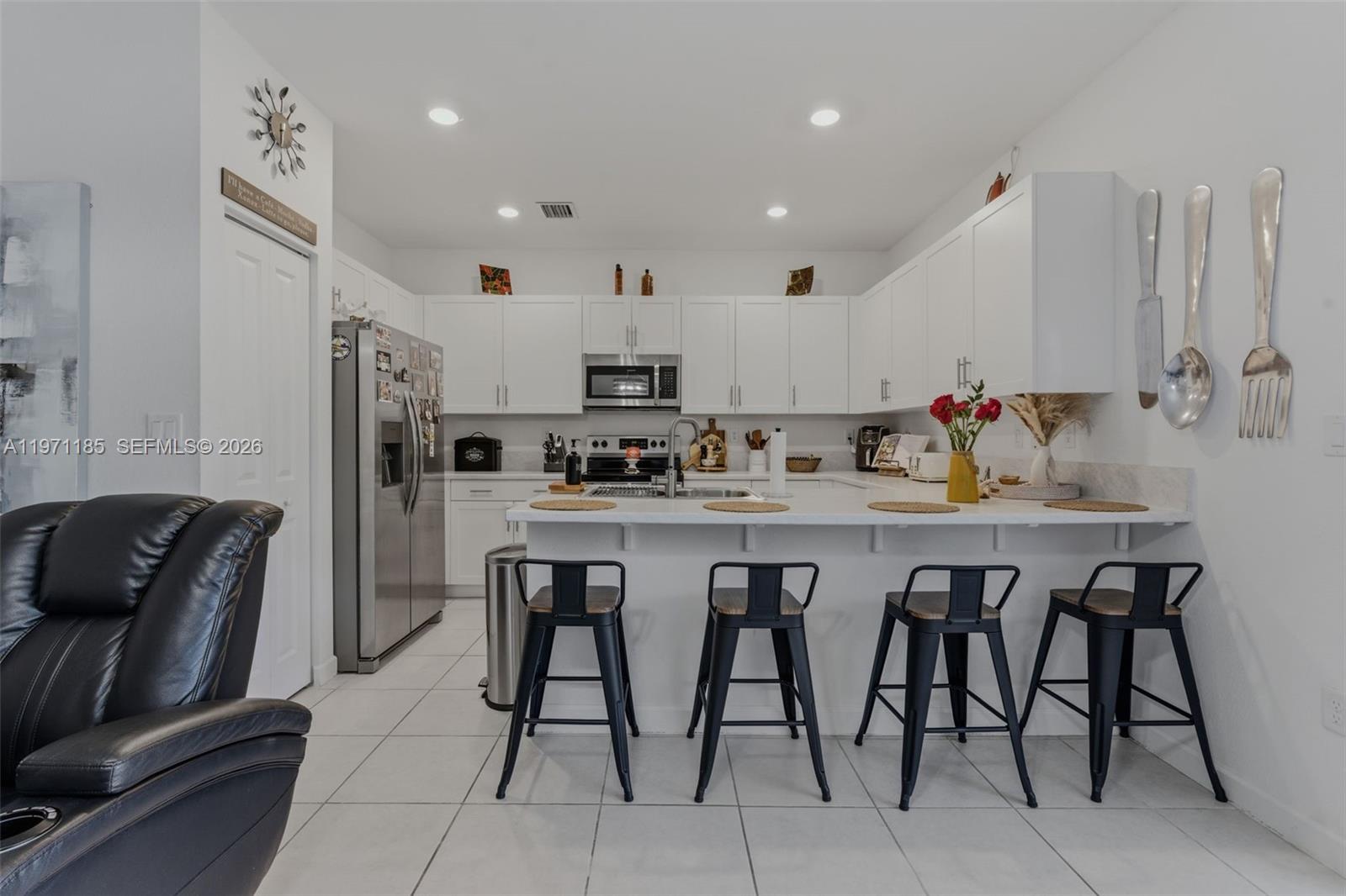 10009 Southwest 228th Terrace Miami, FL 33190 - Photo 9 of 48 a kitchen with stainless steel appliances granite countertop a table chairs sink and cabinets