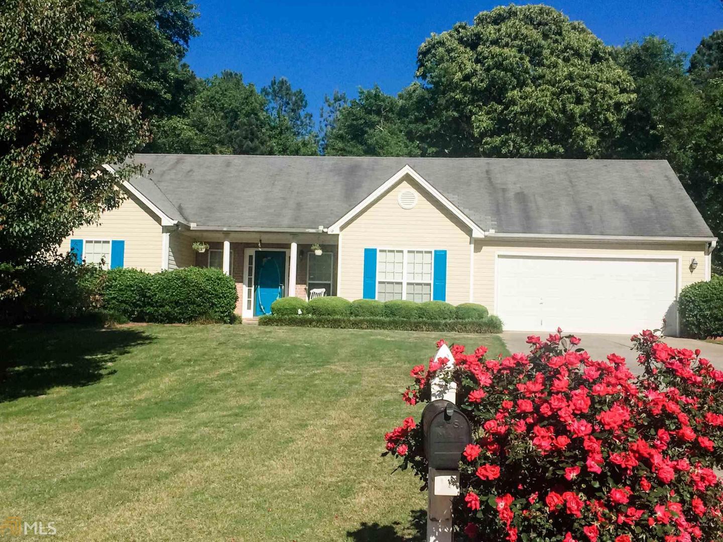 2203 Wagon Wheel Trail Statham, GA 30666 - Photo 1 of 1 a front view of house and yard with beautiful flowers and green space