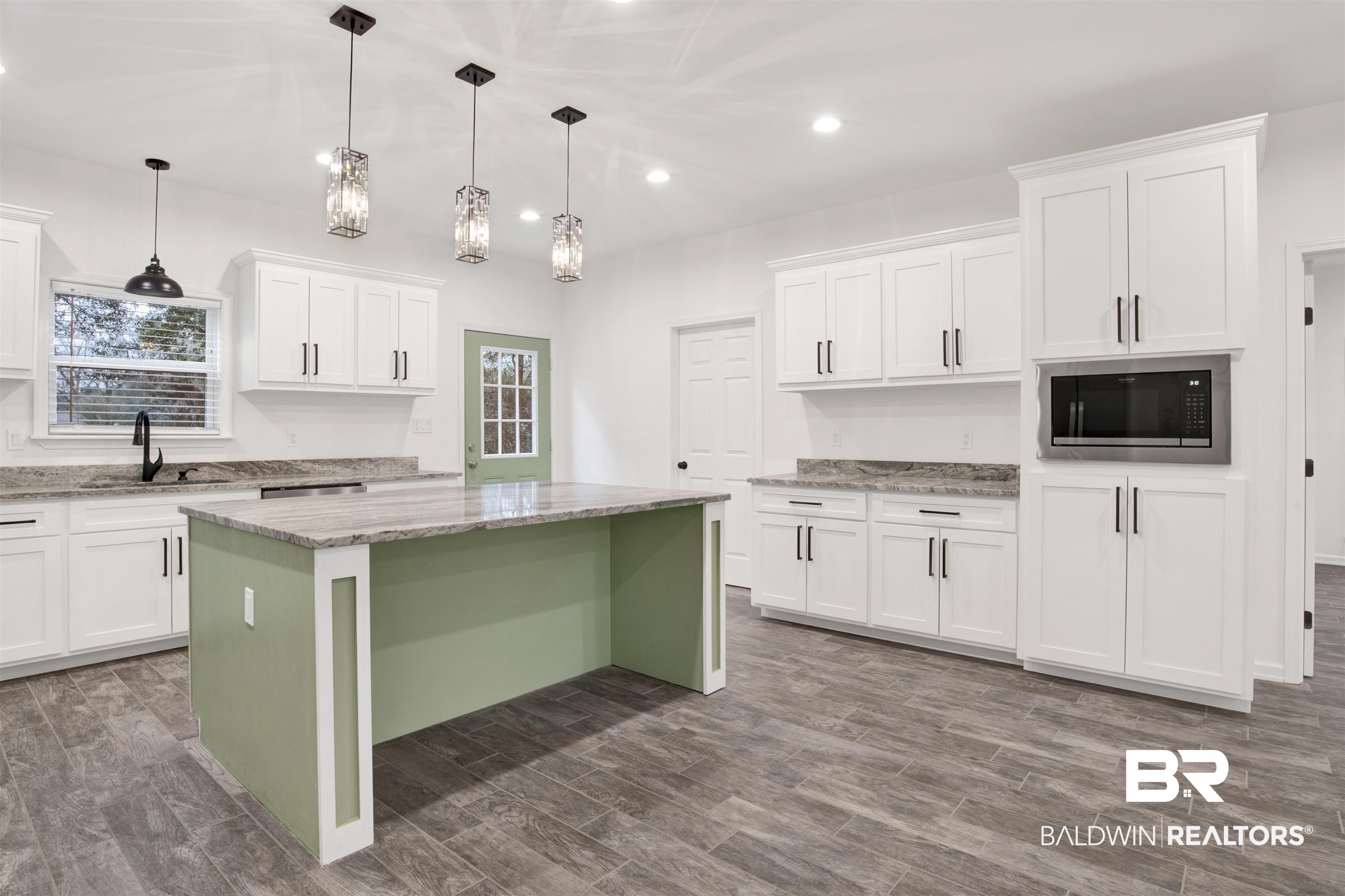 10871 Somerset Road Grand Bay, AL 36541 - Photo 11 of 31 Kitchen featuring sink, a kitchen island, white cabinetry, and decorative light fixtures