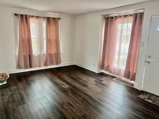 a view of a small space with wooden floor and a window