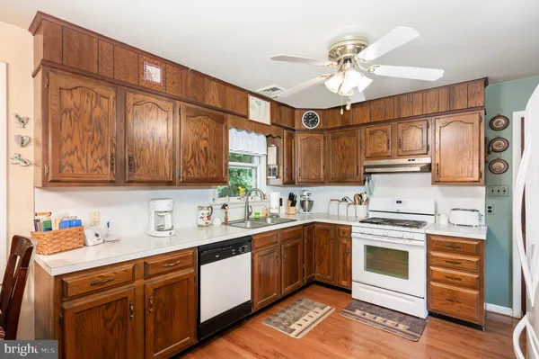 a kitchen with stainless steel appliances a stove a table a sink refrigerator and cabinets