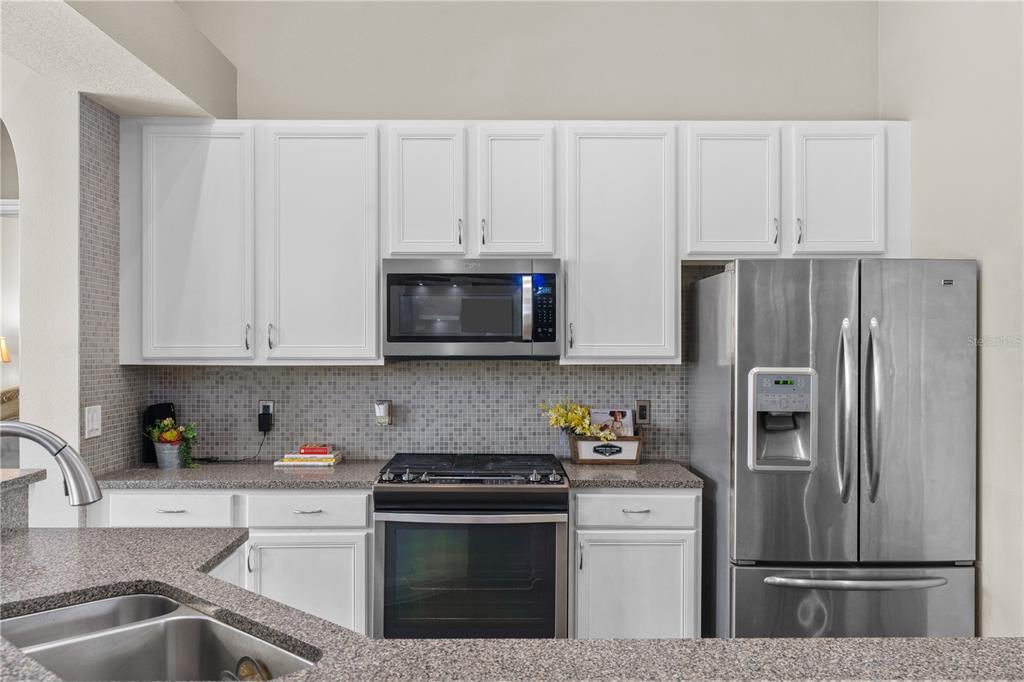 14624 Kitlanselt Way Orlando, FL 32828 - Photo 18 of 42 a kitchen with stainless steel appliances granite countertop a refrigerator sink and stove