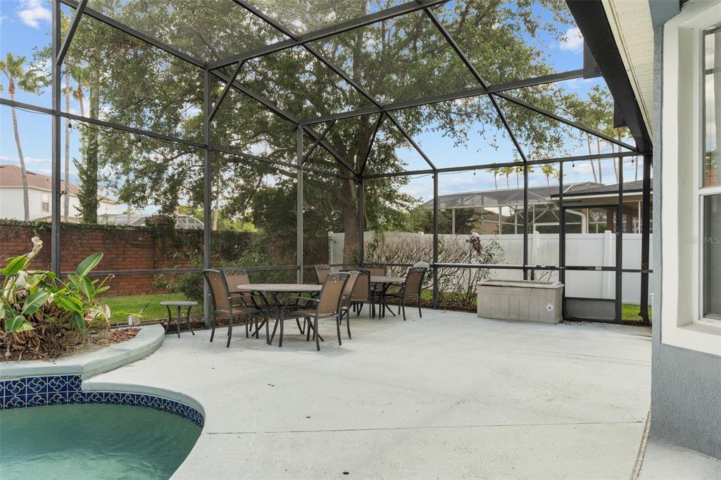 14624 Kitlanselt Way Orlando, FL 32828 - Photo 32 of 42 a view of a patio with table and chairs potted plants with large tree