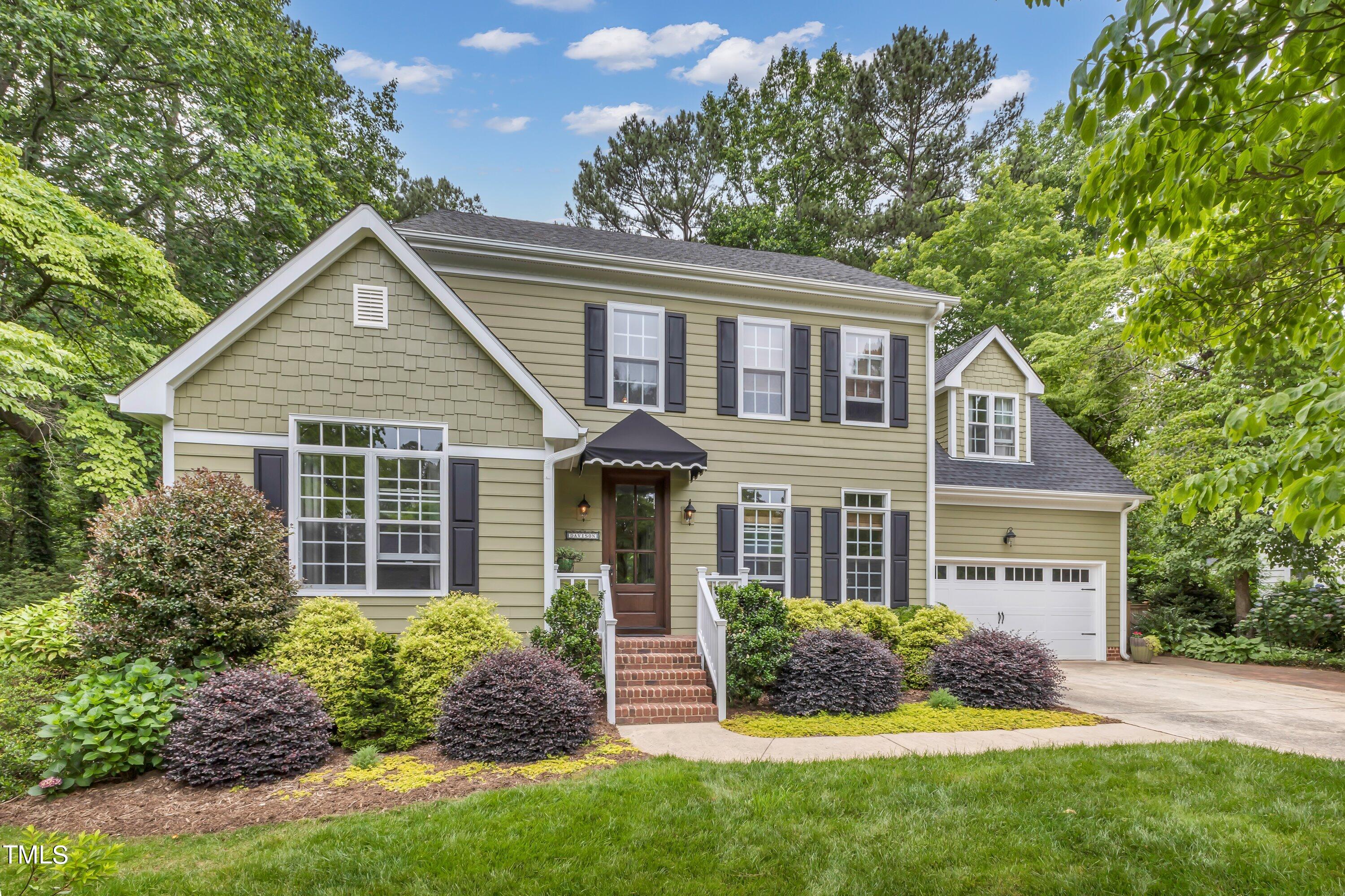 a front view of a house with a yard and potted plants