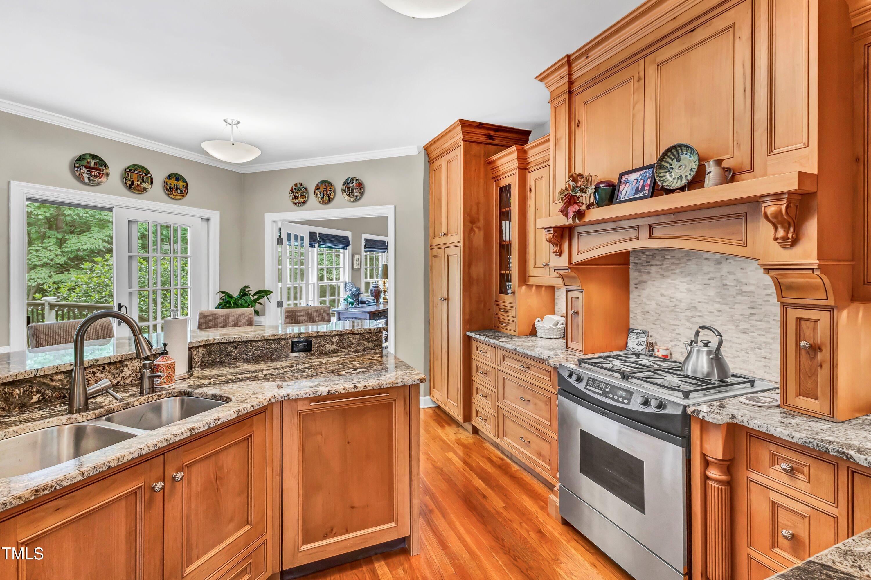 6105 Montcastle Court Raleigh, NC 27612 - Photo 17 of 44 a kitchen with granite countertop a stove and a sink