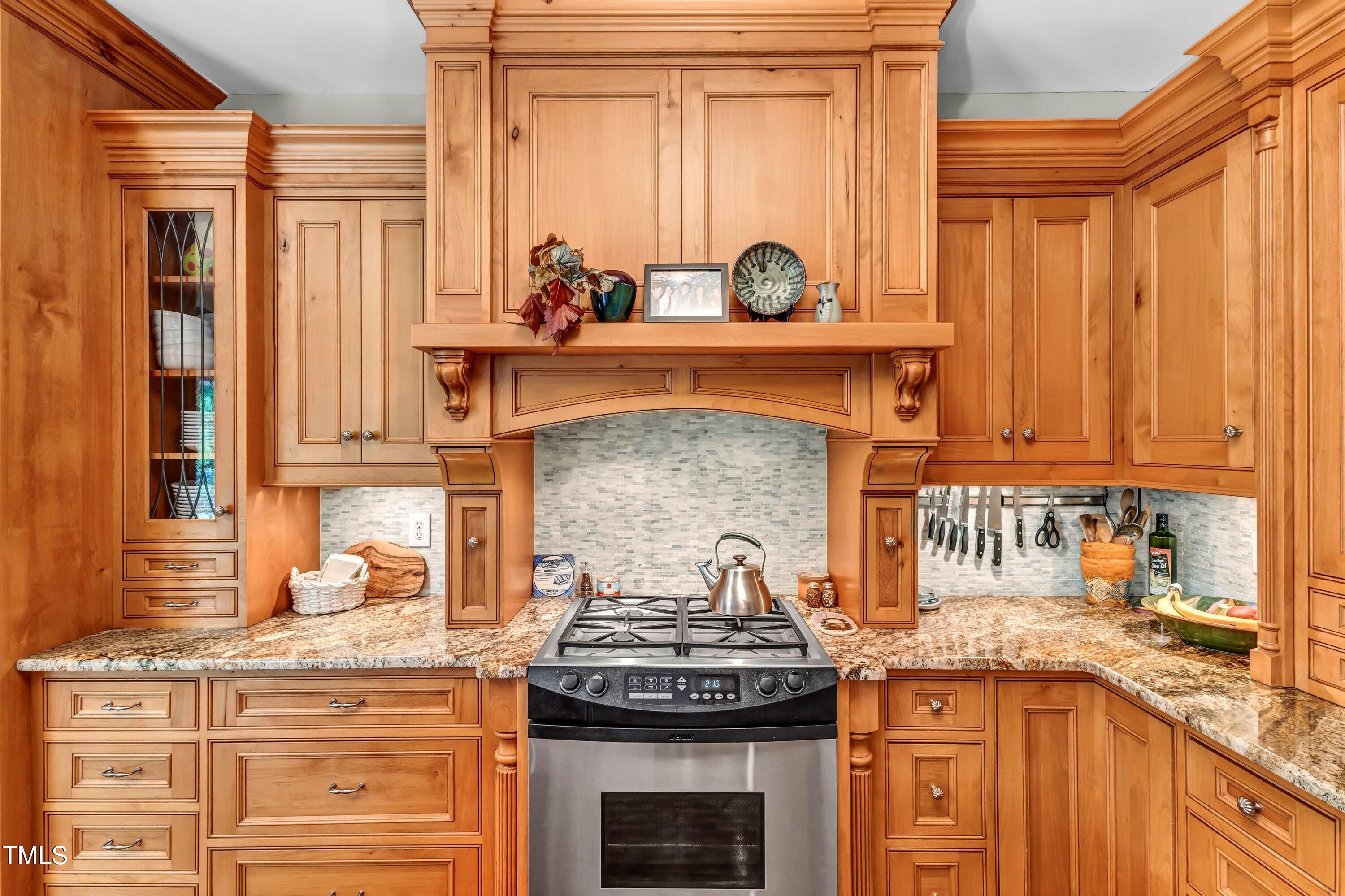 6105 Montcastle Court Raleigh, NC 27612 - Photo 18 of 44 a kitchen with granite countertop a stove and a sink