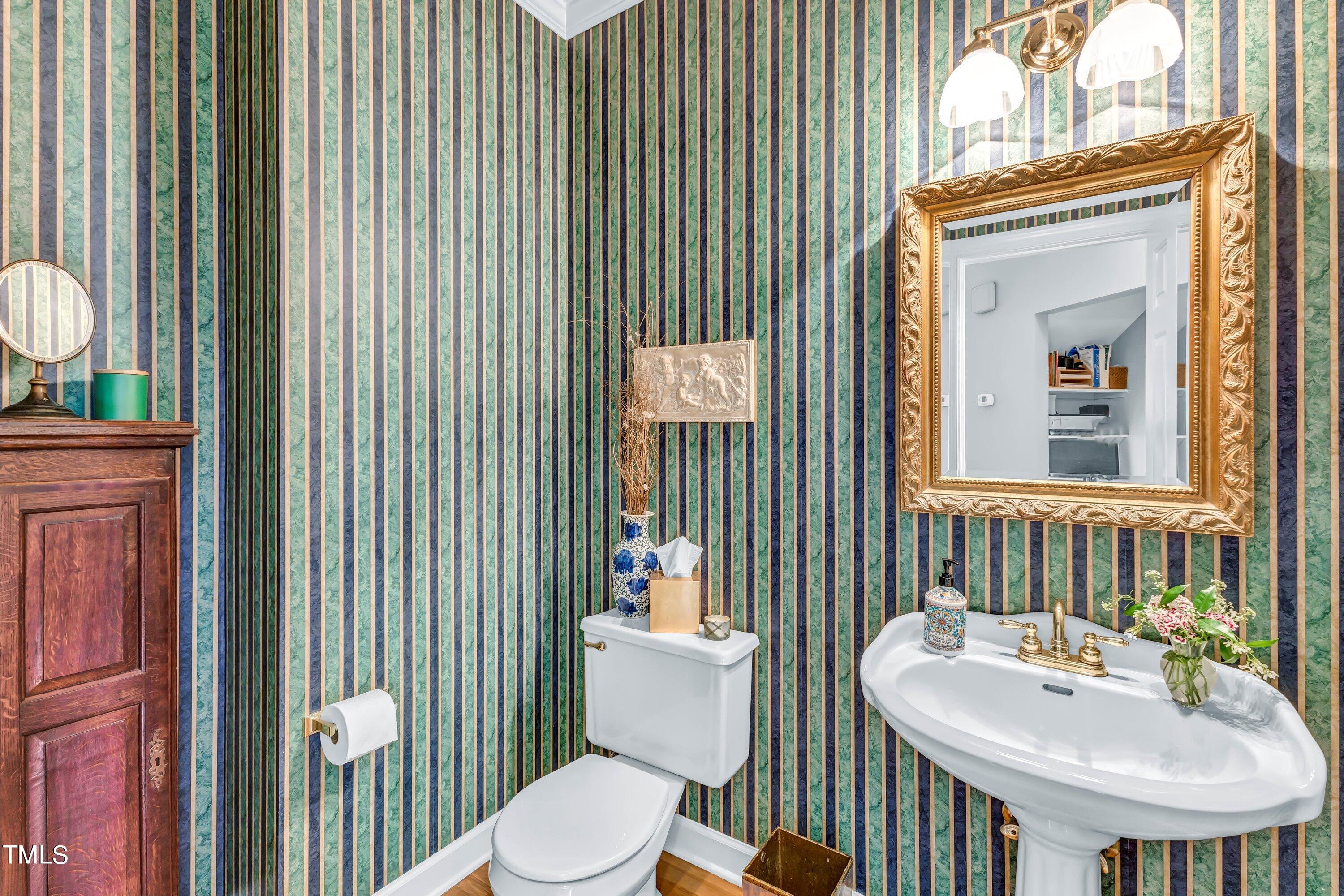 6105 Montcastle Court Raleigh, NC 27612 - Photo 23 of 44 a bathroom with a sink a toilet and mirror