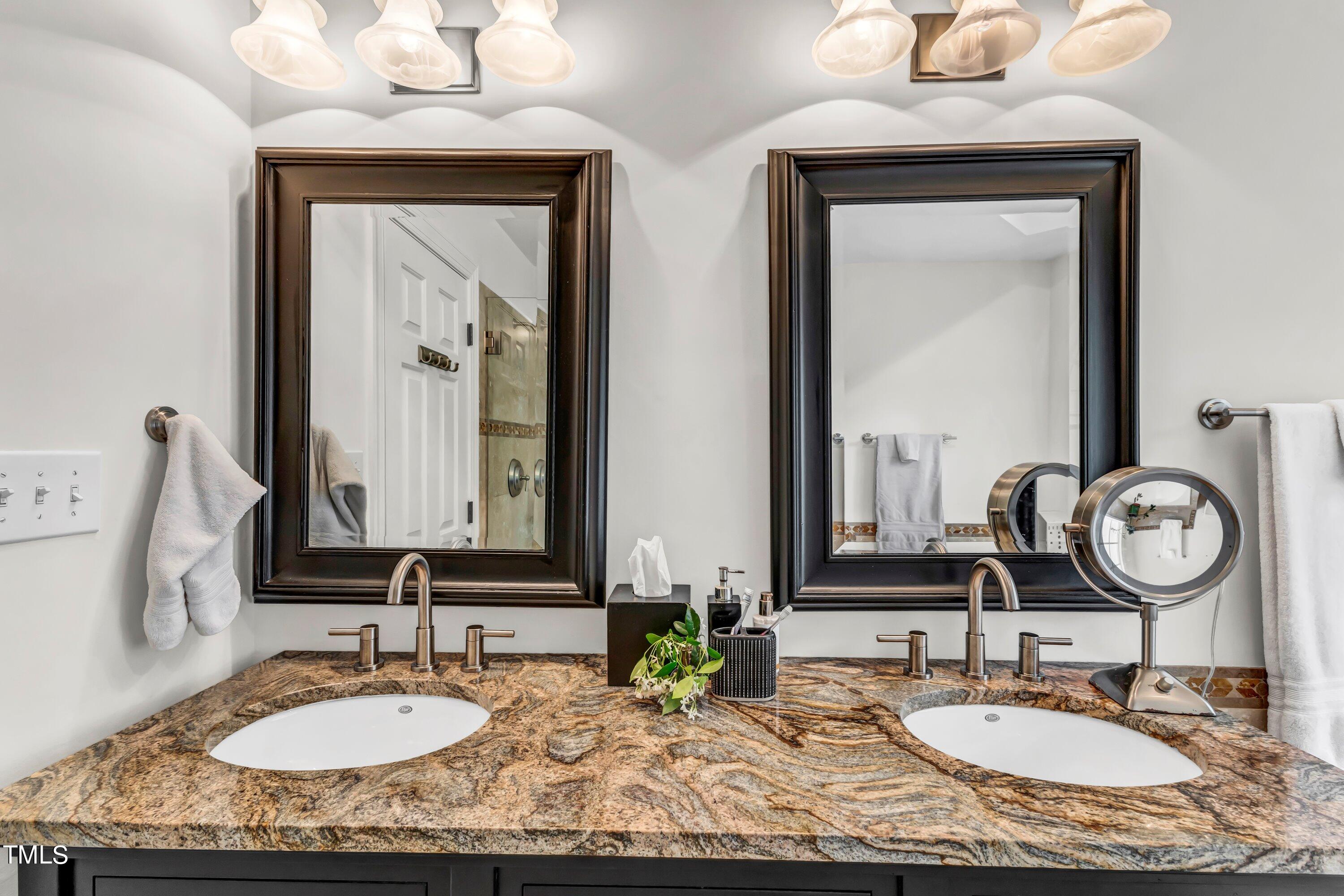 6105 Montcastle Court Raleigh, NC 27612 - Photo 29 of 44 a bathroom with double vanity sinks and a mirror