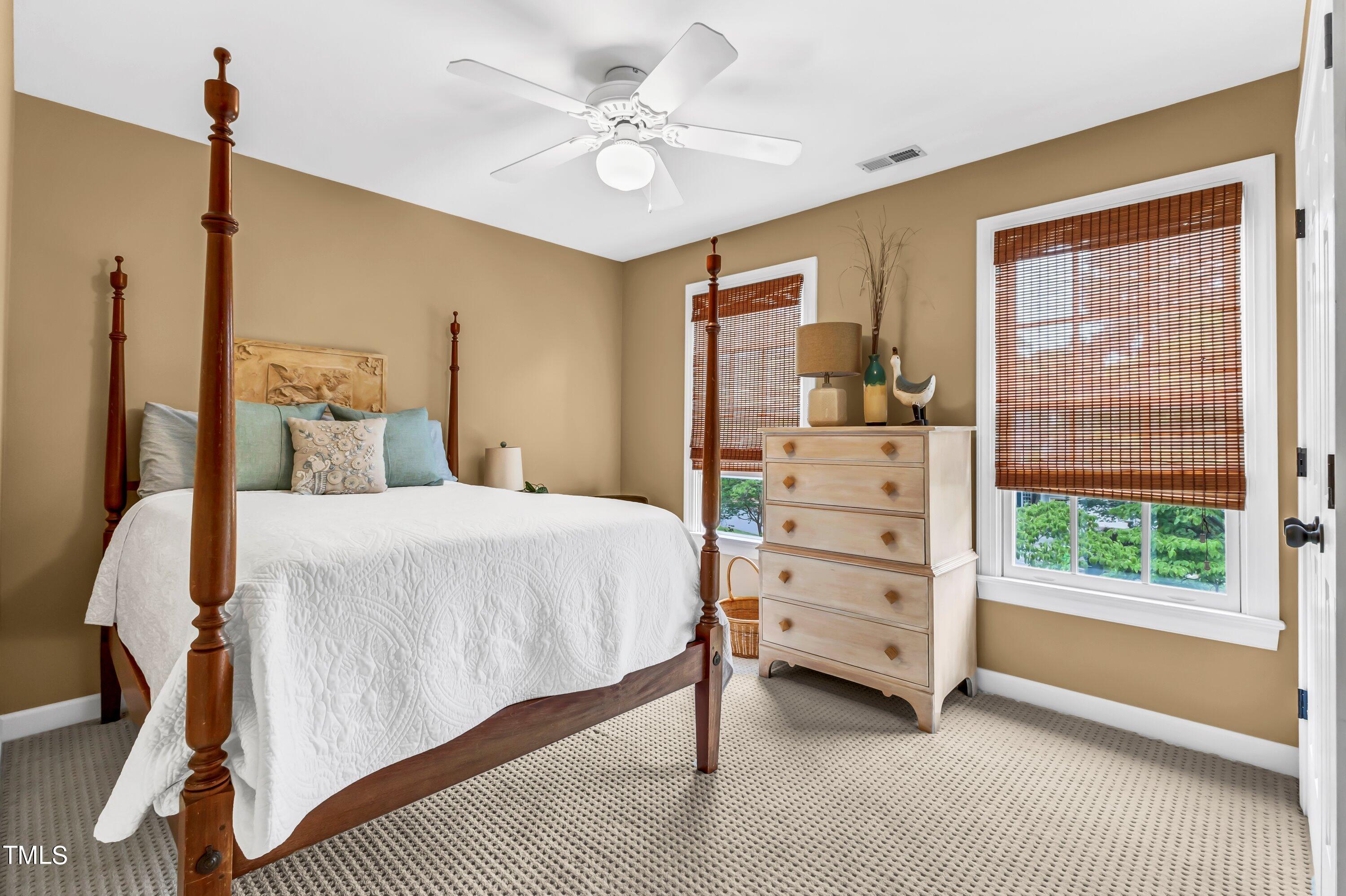 6105 Montcastle Court Raleigh, NC 27612 - Photo 32 of 44 a bedroom with a bed a dresser and a window