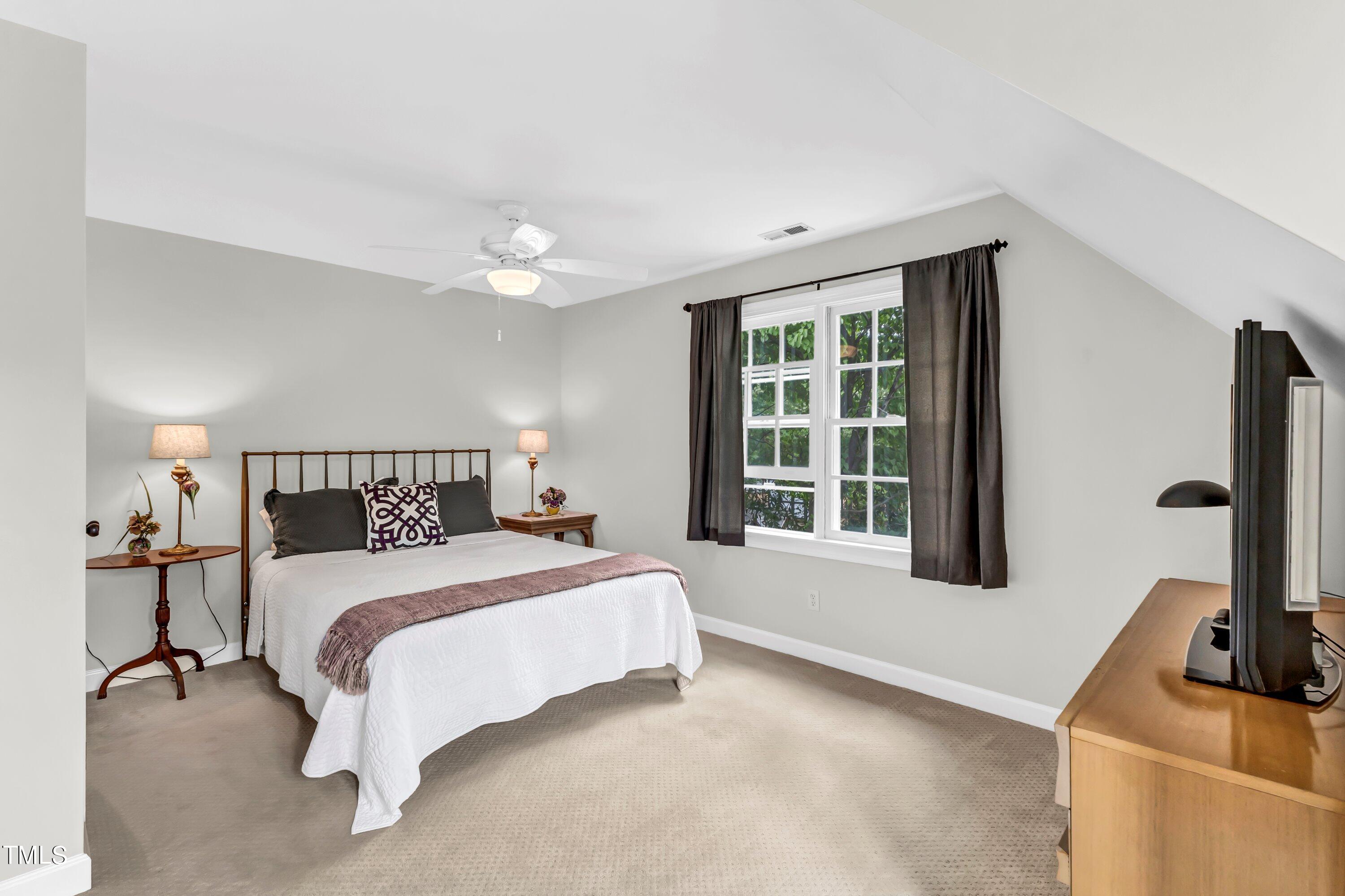 6105 Montcastle Court Raleigh, NC 27612 - Photo 34 of 44 a bedroom with a bed flat screen tv and window