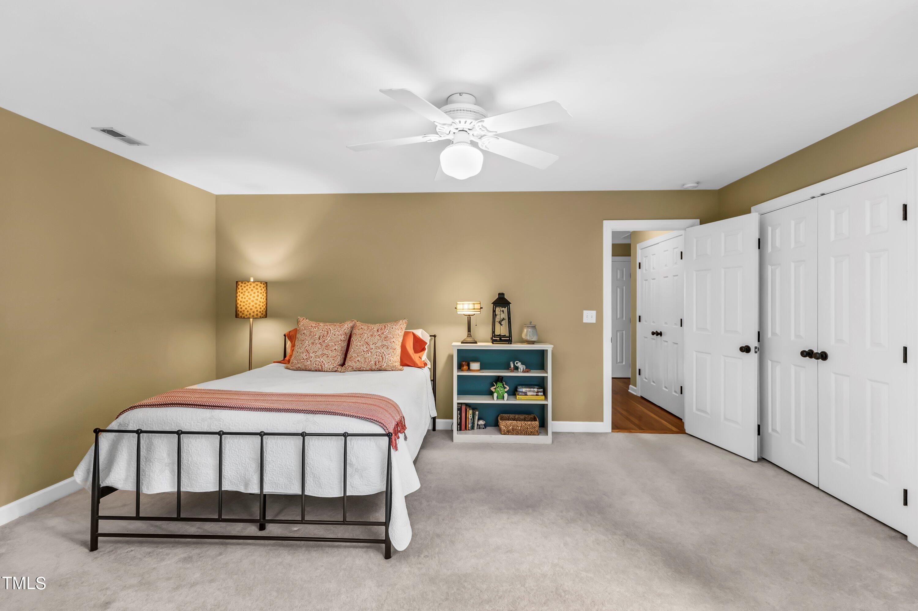 6105 Montcastle Court Raleigh, NC 27612 - Photo 35 of 44 a bedroom with a bed and a chandelier