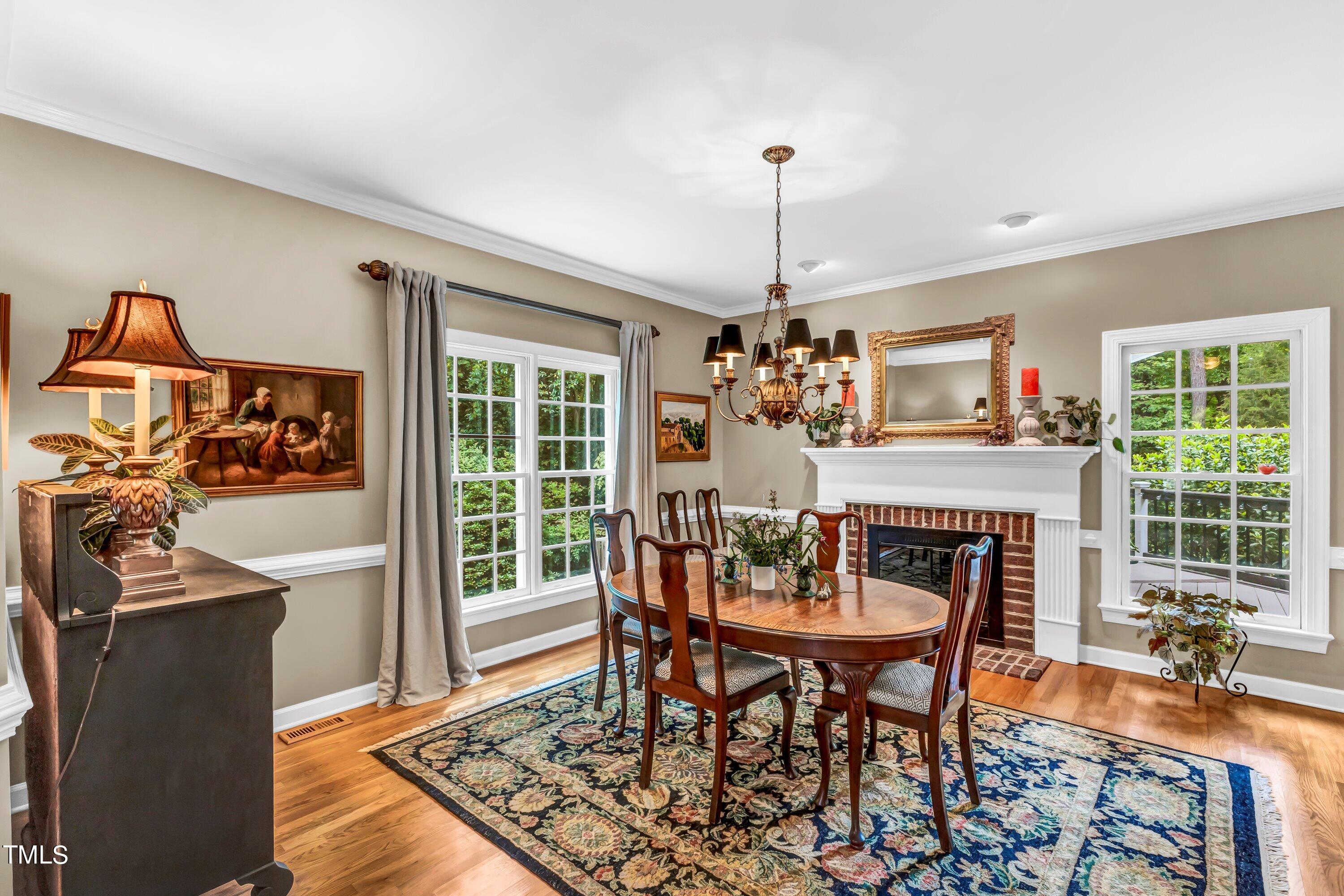 6105 Montcastle Court Raleigh, NC 27612 - Photo 10 of 44 a dining room with furniture a chandelier and wooden floor