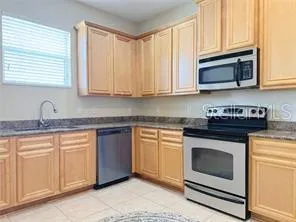 a kitchen with stainless steel appliances granite countertop a stove a sink and a refrigerator
