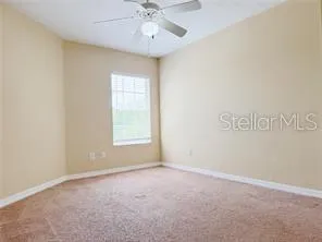 a view of an empty room with a chandelier fan