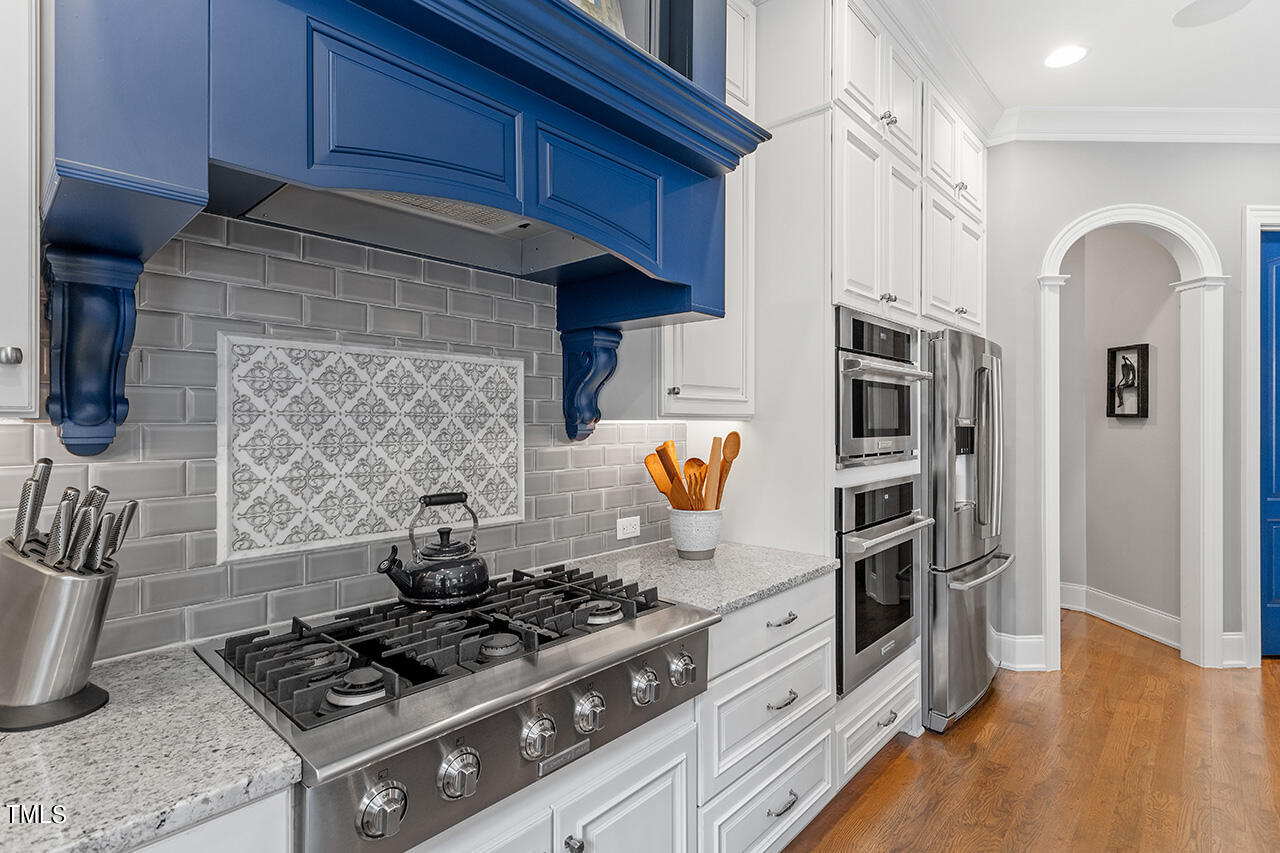 6940 Bartons Bend Way Raleigh, NC 27614 - Photo 23 of 66 a kitchen with stainless steel appliances granite countertop a stove and a wooden cabinets