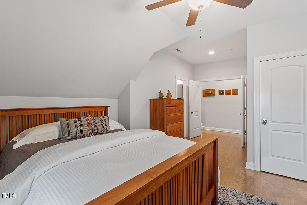 6940 Bartons Bend Way Raleigh, NC 27614 - Photo 39 of 66 a bedroom with a large bed and a chandelier
