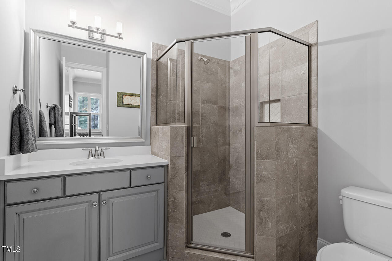 6940 Bartons Bend Way Raleigh, NC 27614 - Photo 40 of 66 a bathroom with a shower sink vanity and mirror