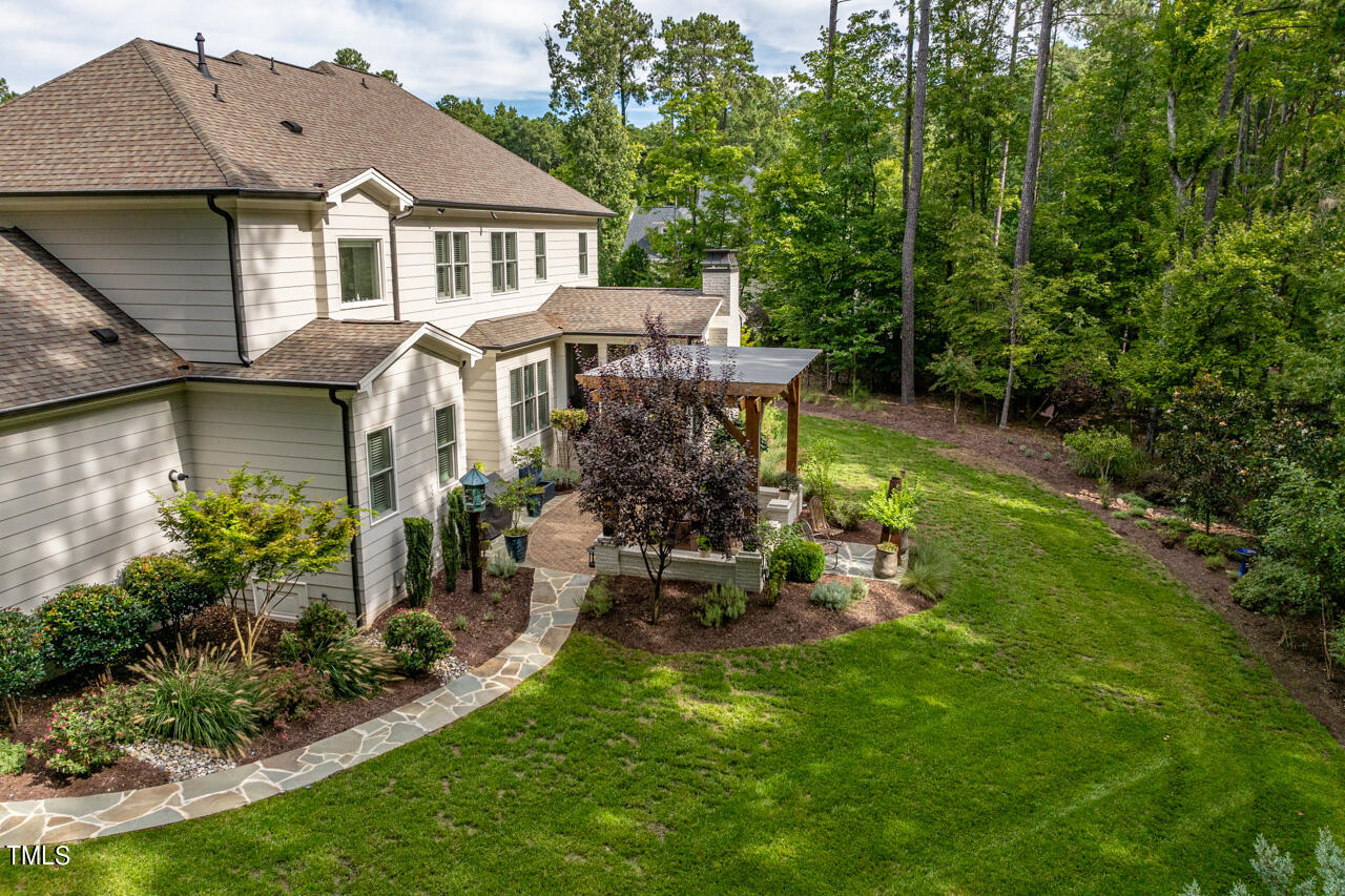 6940 Bartons Bend Way Raleigh, NC 27614 - Photo 56 of 66 a front view of a house with a garden and sitting area